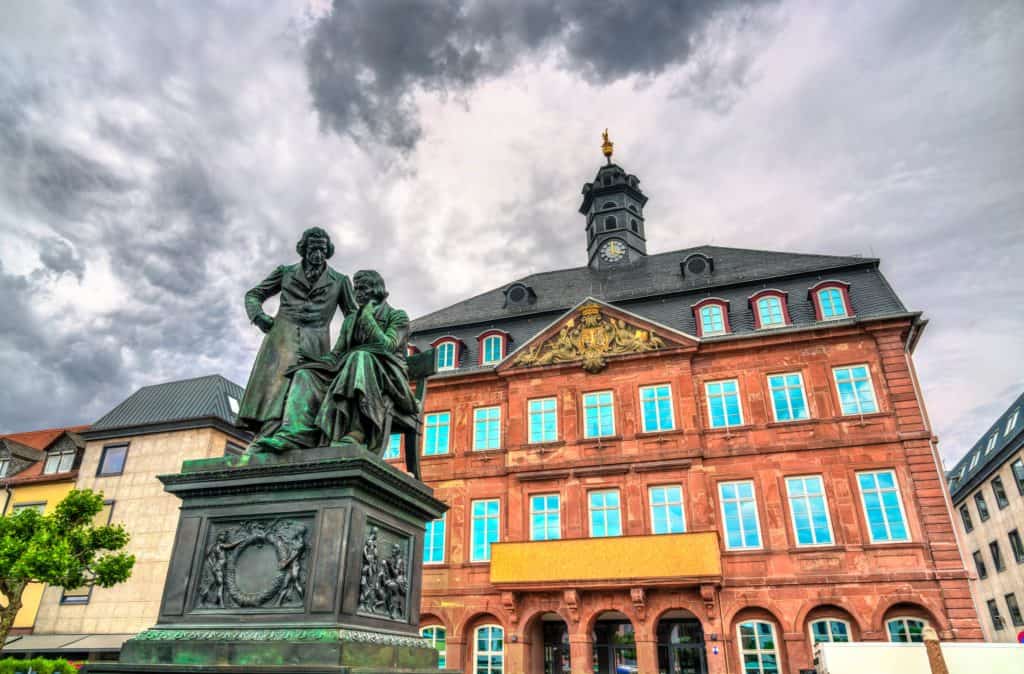 Statue der Gebrüder Grimm vor dem historischen Rathaus in Hanau, perfekt für Immobilienmakler, die kulturell bedeutende Objekte präsentieren.
