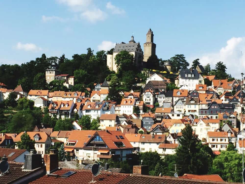 Blick auf Kronberg mit seiner klassischen Burg und dicht bebauten Wohnhäusern, ein attraktives Gebiet für Immobilienmakler.