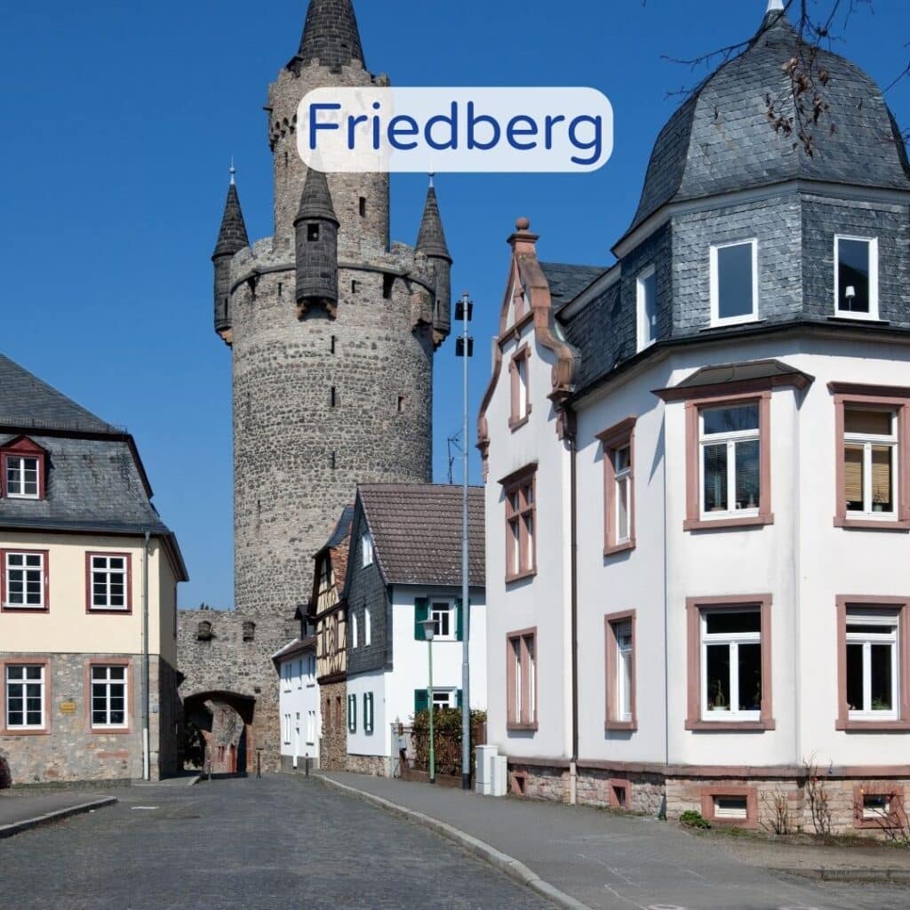 Burg von Friedberg mit einem Torbogen und einem Turm bei Tageslicht.
