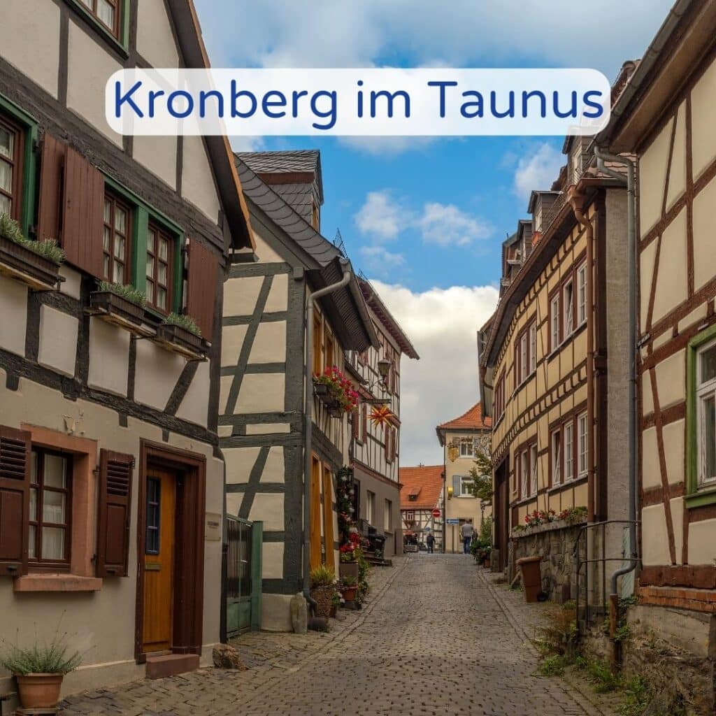 Schmale Gasse in Kronberg im Taunus mit traditionellen Häusern und Kopfsteinpflaster.