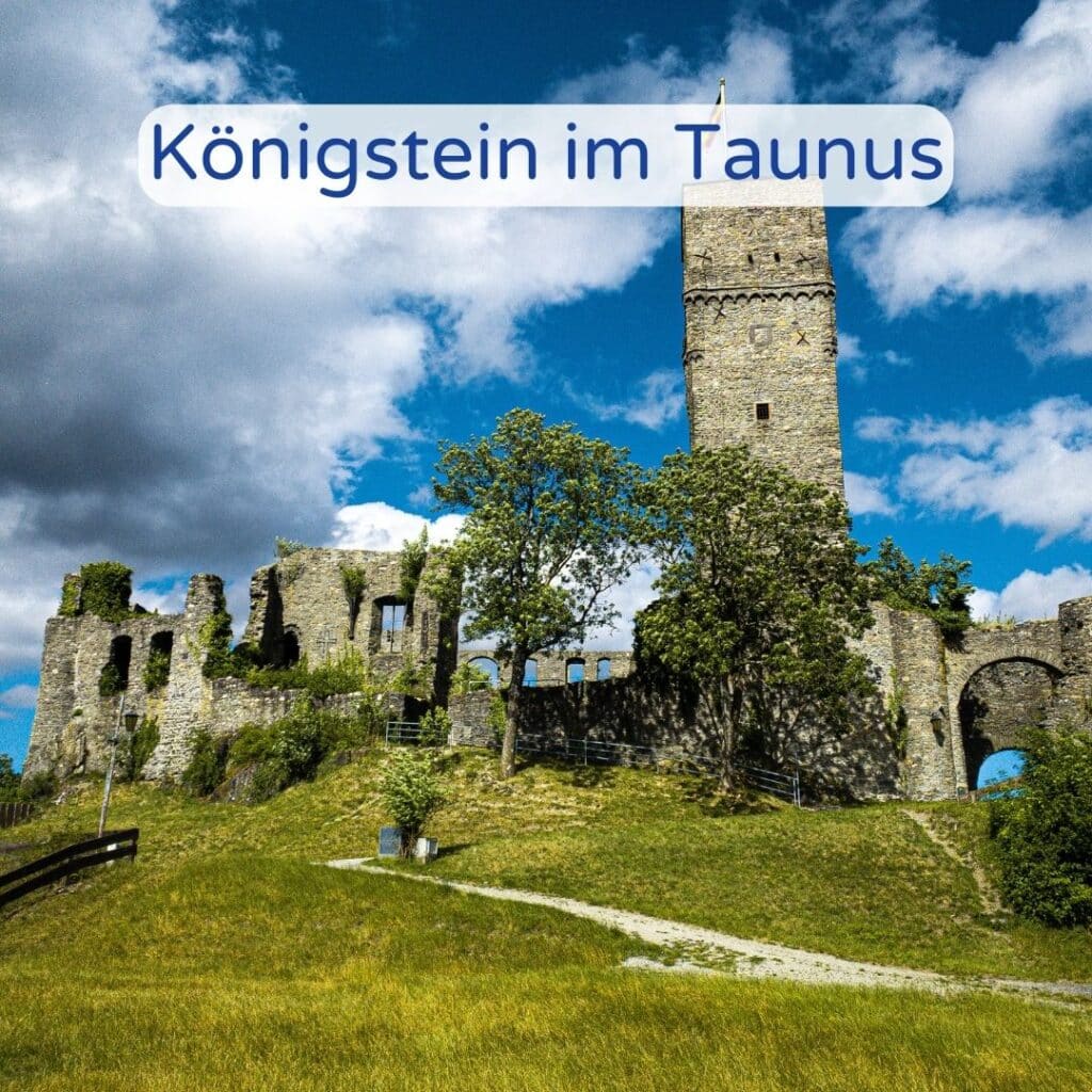 Ruine der Burg Königstein im Taunus mit grüner Wiese und Bäumen.