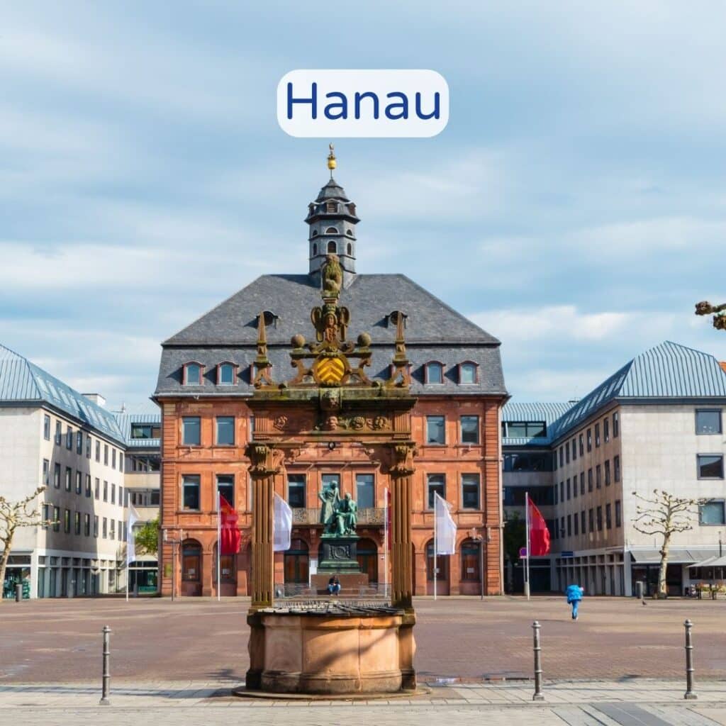 Marktplatz in Hanau mit einem Brunnen und umgebenden Gebäuden.