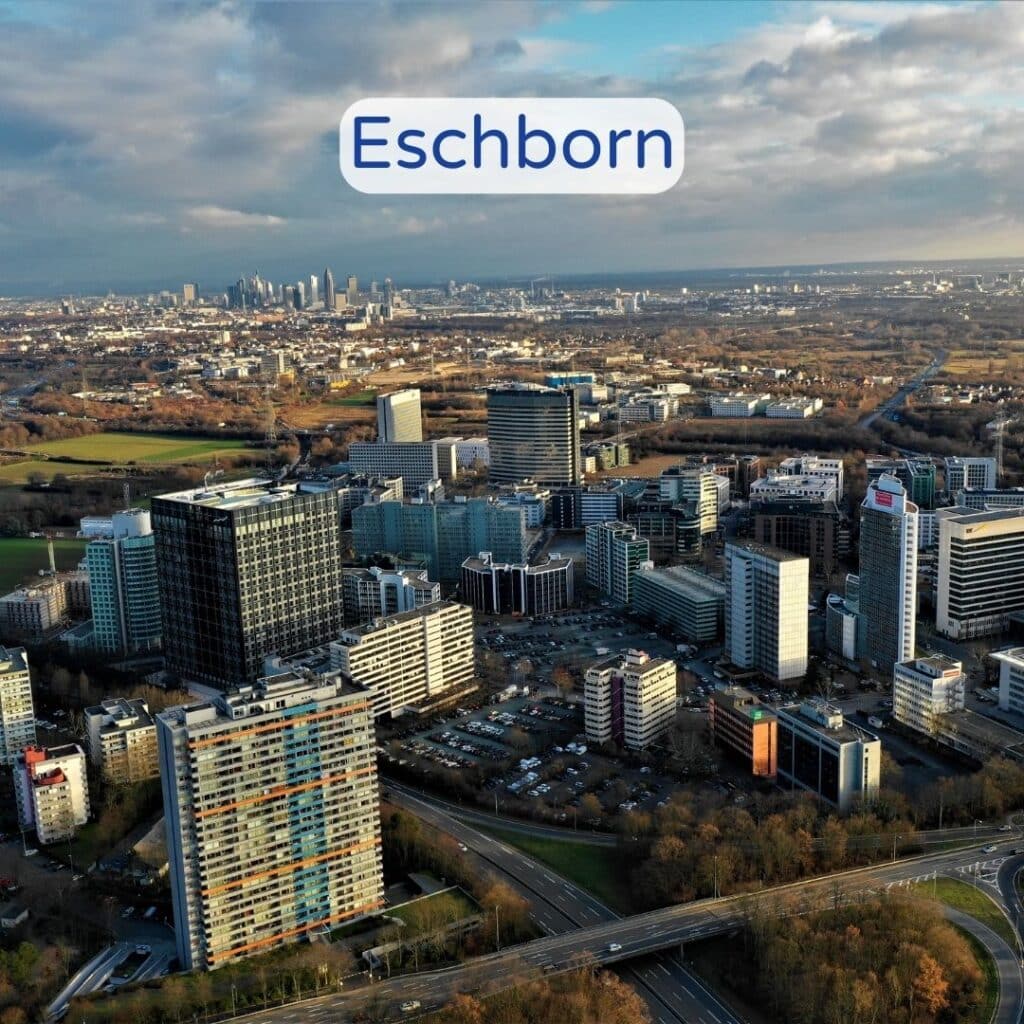 Blick auf moderne Bürogebäude in Eschborn mit bewölktem Himmel im Hintergrund.